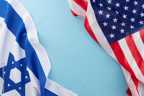 United States - Israel cooperation concept. Top view composition of American flag and Israeli flag on soft blue background with blank space for special text