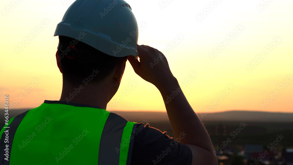 A tired worker took off his helmet at day's end A tired worker took off his helmet at day's end