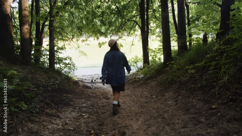 Woman walking in the forest on summer sunny day close up. Female wonder in the park. A beautiful view of park Woman walking in the forest on summer sunny day close up. Female wonder in the park. A beautiful view of park