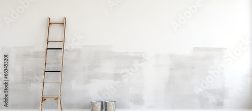 Painting wall white in room of a apartment after relocation with ladder and paint bucket photo