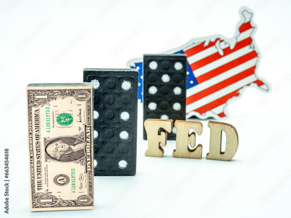 dollar banknote on dominoes with fed in between dominoes piece and us flag on white background, financial crisis concept dollar banknote on dominoes with fed in between dominoes piece and us flag on white background, financial crisis concept