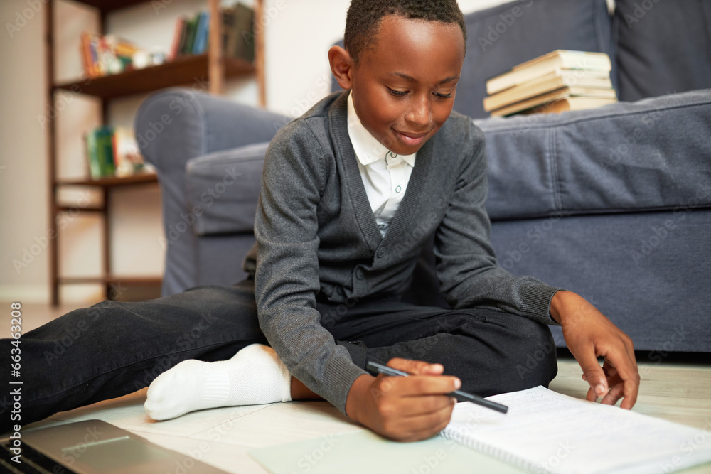 Homeschooling, remote education, distant learning. Side view of smart black boy in school uniform study online, sitting on floor in front of laptop, making research, doing math, writing in copybook Homeschooling, remote education, distant learning. Side view of smart black boy in school uniform study online, sitting on floor in front of laptop, making research, doing math, writing in copybook
