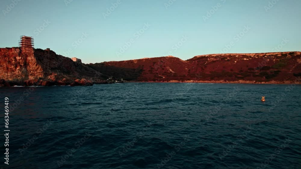 Aerial view of people doing surf at sunset at Qarraba Bay, Mgarr, Malta. Aerial view of people doing surf at sunset at Qarraba Bay, Mgarr, Malta.