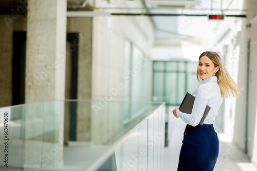 Free Download Young woman with digital tablet walking in the modern office hallway - GFXLoad