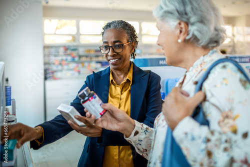 Diverse pair of senior female friends browsing the shelfs of a drugstore photo