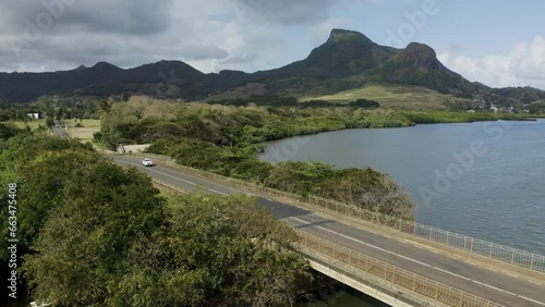 Mauritius - 21 September 2023: Aerial view of a beautiful car driving across a bridge along the coast. photo