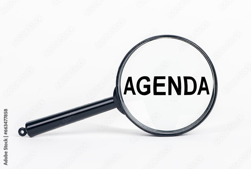 Agenda word through magnifying glass, loupe Agenda word through magnifying glass, loupe