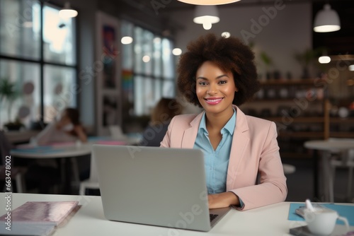 A woman working on her laptop at a table © pham