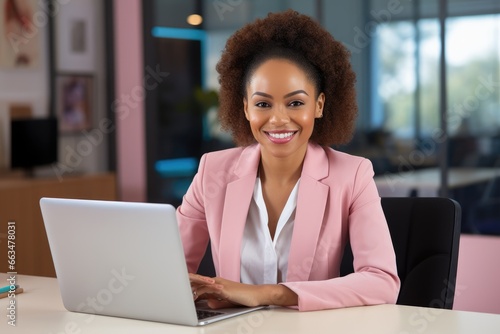 A woman working on a laptop at a desk