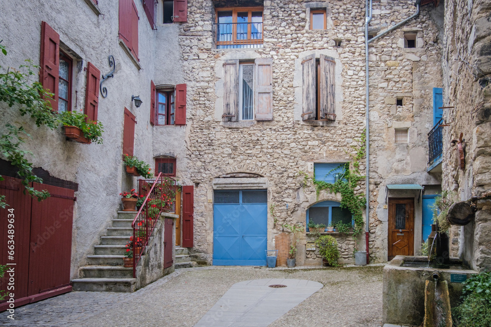  Old stone house fa¸çade with blue shutters and fountain in the medieval village of Chatillon En Diois in the south of France (Drome)
