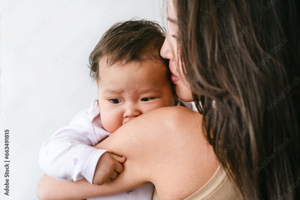Young asian mother holding little baby girl and smiling Young asian mother holding little baby girl and smiling