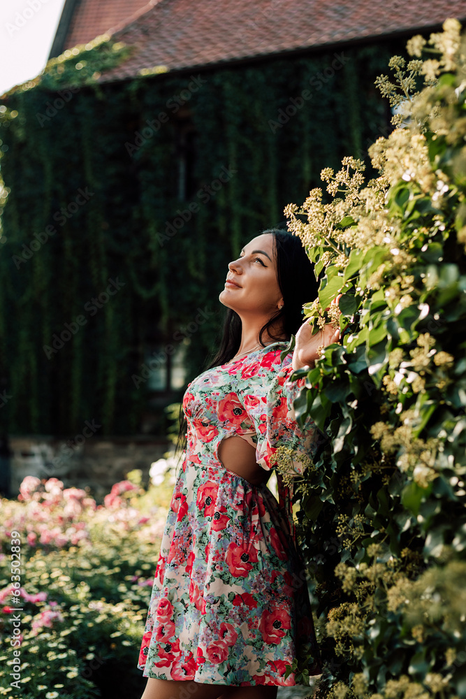 Attractive woman in a dress walks around the city. Green plants in the old town Attractive woman in a dress walks around the city. Green plants in the old town