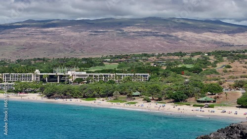 Aerial coastal resort public beach Kona Hawaii 1 pan. Big Island. Economy is tourism based. Volcanic lava rock, black sand and white sand beach. Water tropical beach recreation and fun. photo