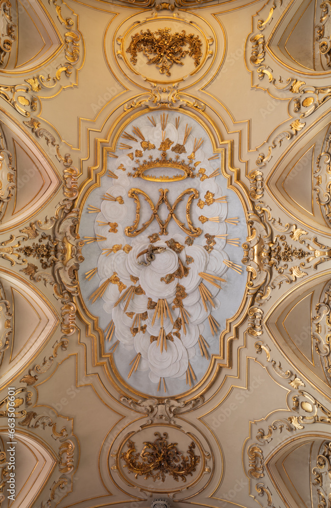 NAPLES, ITALY - APRIL 19, 2023: The baroque ceiling stucco with the marianic initials and symboli in the church Chiesa del Jesu Vecchio.