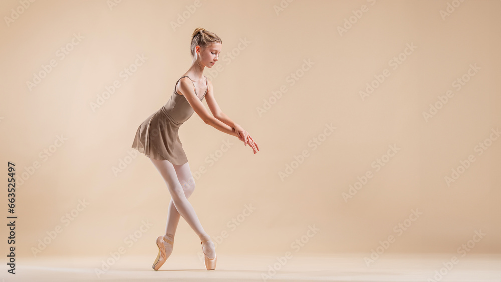Beautiful young girl professional student ballerina in pointe shoes and a leotard on a light beige background. - obrazy, fototapety, plakaty 