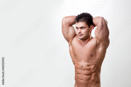 side view of a muscular athlete fit bodybuilder man on a whiet background. Space for text.