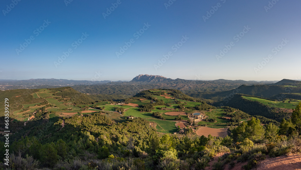 Spring in Catalonia. Montserrat over the green fields. A panoramic view from Turó de les Tres Creus @ Catalonia, Spain.