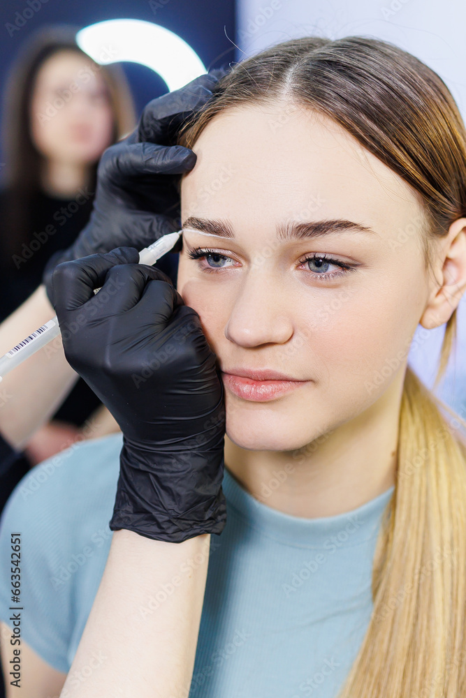 Fototapeta premium Eyebrow marking before permanent makeup. Permanent make-up of eyebrows. Markings with white paste and a measuring ruler