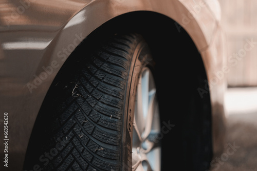 Close-up view of the front wheel of the car with brand-new winter tyres on it. Safety on the road while driving in the winter season. Below zero temperatures. All-season tyres.