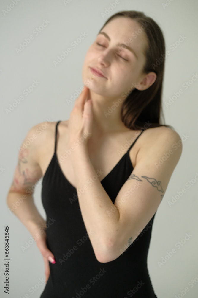 Young brunette girl in black swimming bodysuit on a white background Young brunette girl in black swimming bodysuit on a white background