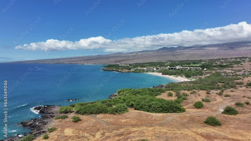 Aerial Kona Hawaii dry landscape to ocean coast pan 2. Big Island destination. Economy is tourism based. Water and tropical beach recreation and fun. Beautiful clear blue ocean sea. Aerial Kona Hawaii dry landscape to ocean coast pan 2. Big Island destination. Economy is tourism based. Water and tropical beach recreation and fun. Beautiful clear blue ocean sea.