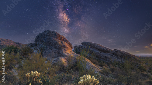 The Milky Way galaxy rising over a lone rocky desert