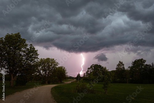 A lightning strike during a thunderstorm in the countryside, a dusky evening with a very overcast sky  © Roberts