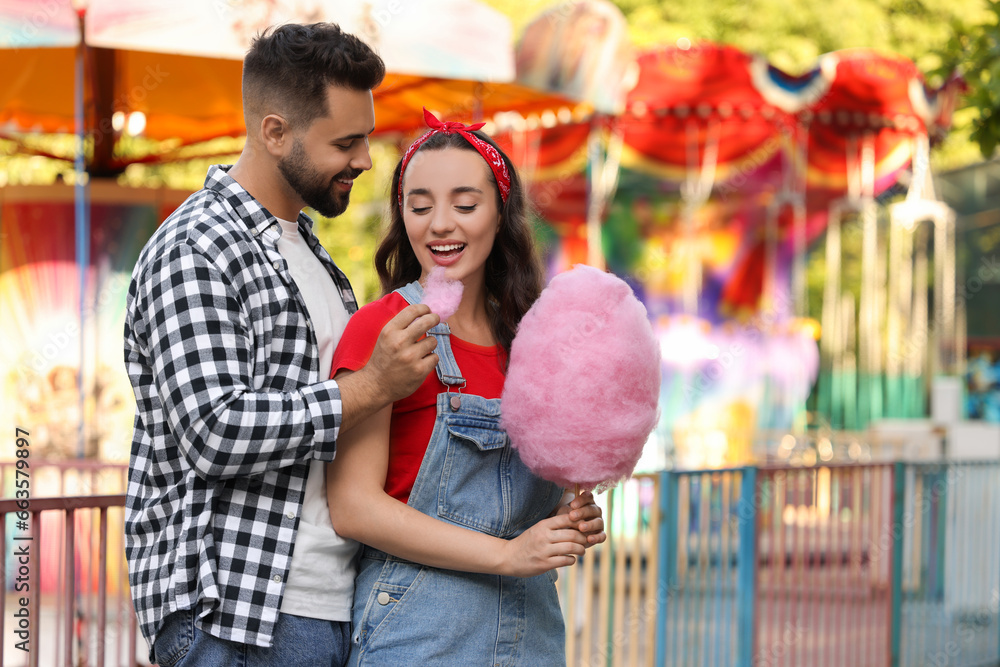 Happy couple with cotton candy at funfair