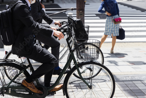 Photography Japanese business men on bicycles on the sidewalk in Tokyo