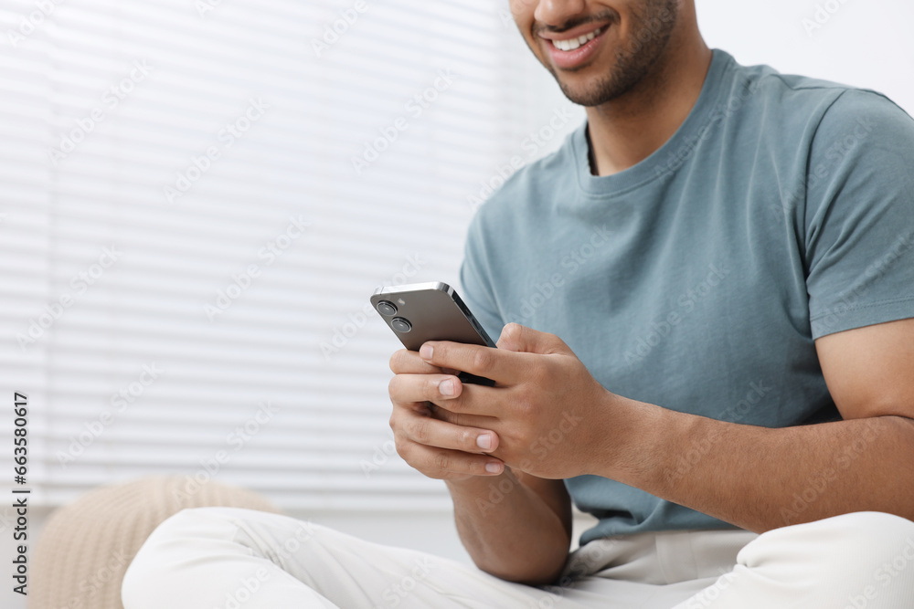 Man using modern mobile phone indoors, closeup. Space for text Man using modern mobile phone indoors, closeup. Space for text