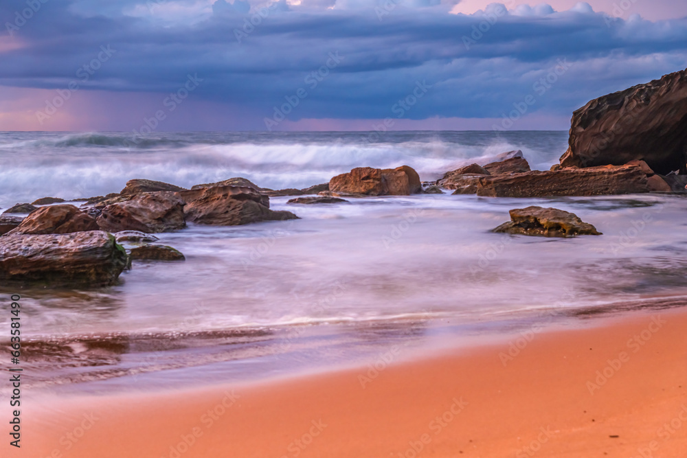 Sunrise seascape with low clouds and waves