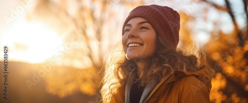 A woman with a beanie smiling at the sun