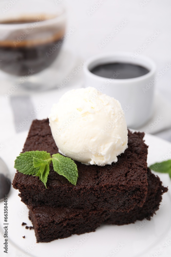 Tasty brownies served with ice cream and mint on table, closeup Tasty brownies served with ice cream and mint on table, closeup