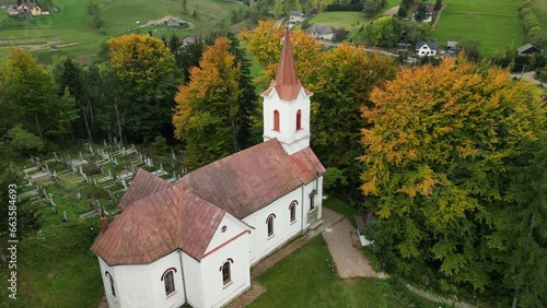 Aerial drone shot of rural catholic church in Sirnea (Șirnea) village near Brasov. Medieval catholic church in Romanian village. Transylvania. photo