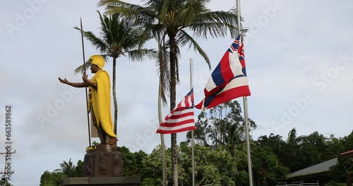 King Kamehameha statue Hawi Hawaii flags side. Kamehameha the Great. Ruler credited with unifying the Hawaiian Islands. Bronze statue cast in 1880 to honor the Hawaiian Islands and their ruler. photo