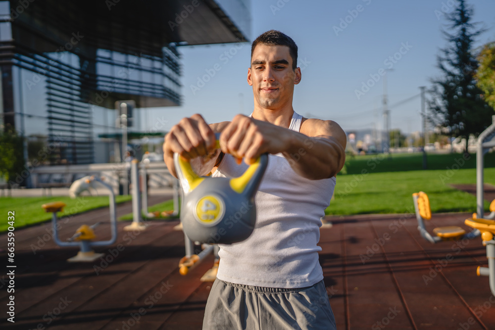 One man young adult caucasian male train with kettlebell girya weight One man young adult caucasian male train with kettlebell girya weight