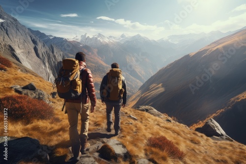 Hikers on Mountain Pathway, Autumnal Grasslands in Foreground, Overlooking Majestic Mountain Ranges in Soft Sunlit Glow