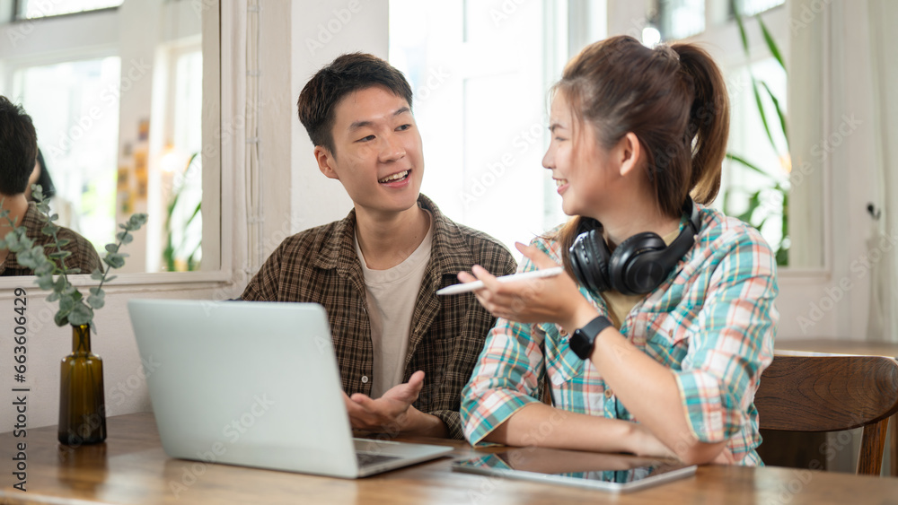A happy Asian man and his female friend are working on a project together, sharing ideas as a team. A happy Asian man and his female friend are working on a project together, sharing ideas as a team.