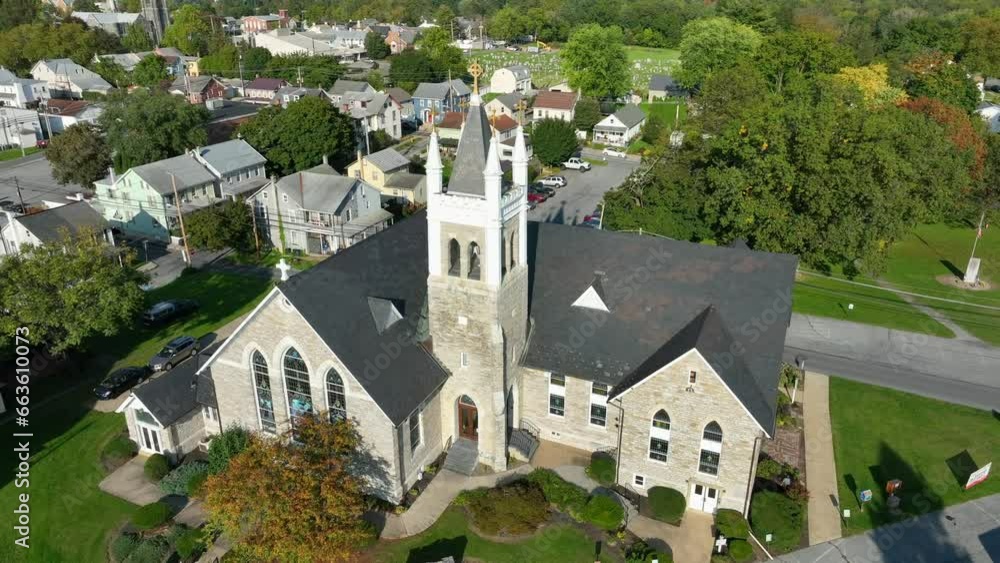 Church in American town. Aerial shot during bright sunset. Religion theme in USA. Old historic building with steeple. Church in American town. Aerial shot during bright sunset. Religion theme in USA. Old historic building with steeple.