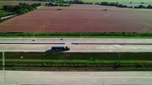 tracking aerial of a black Conestoga - flatbed Semi Trailer Truck driver driving on interstate. Great concept for hiring truck drivers or owner operators. photo
