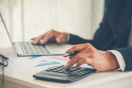 Close up man hands Asian businessman  calculating number, audit planning on business report Asian Business man hands using calculator counting tax financial bill. Tax audit Finacial concept
