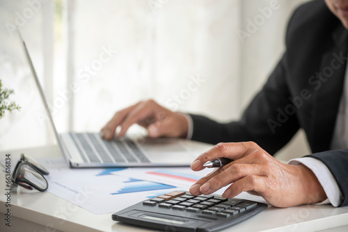 Close up business man hands using calculator counting tax financial bill. Man hands calculating number  data  graph  chart audit planning accountancy on business report. Tax audit Finacial concept.