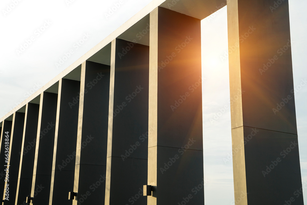 Row of columns or poles structure with tree, sunlight and blue sky background . Strong and monument concept . Row of columns or poles structure with tree, sunlight and blue sky background . Strong and monument concept .