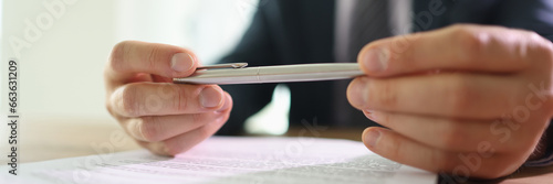 Cuadro en lienzo Doubting businessman holds ball pen in hands above papers