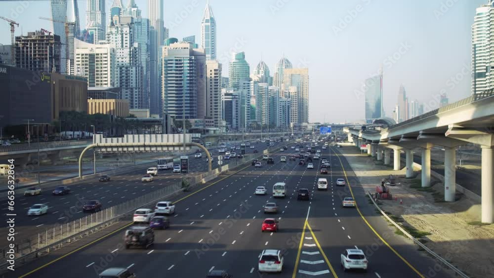 The active Dubai's Sheikh Zayed Road at dusk, with the metro passing beside the iconic skyline and bustling vehicles. The active Dubai's Sheikh Zayed Road at dusk, with the metro passing beside the iconic skyline and bustling vehicles.