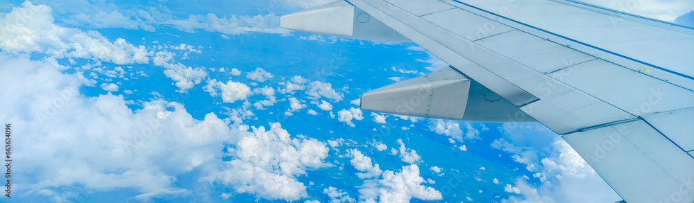 Fototapeta premium Enjoying the tranquil sky through an airplane window, a serene journey above the clouds. Scenic aerial view. Travel concept, traveler, trip, vacation, tourism