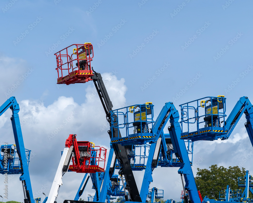 Group of aerial work platforms for construction and material handling. Close-up to the basket for moving people Group of aerial work platforms for construction and material handling. Close-up to the basket for moving people