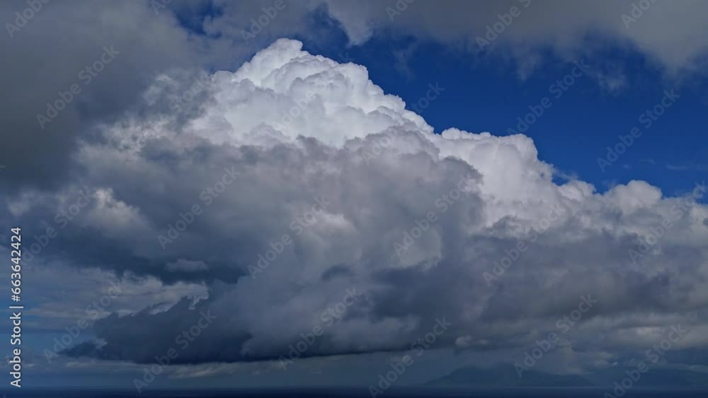 Dense clouds moving through the blue sky during the day Dense clouds moving through the blue sky during the day