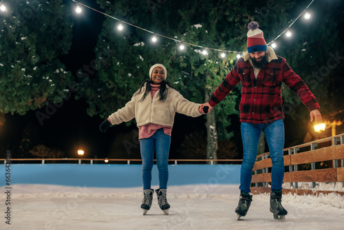 Young couple in love is enjoying winter day skating