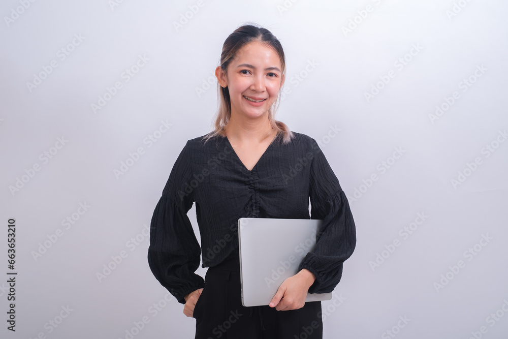 Happy adult professional business lady in black dress and wearing glasses holding notebook laptop looking at camera against gray background. Using digital online technology for work or education. Happy adult professional business lady in black dress and wearing glasses holding notebook laptop looking at camera against gray background. Using digital online technology for work or education.